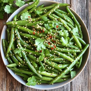 - 1 pound fresh green beans, trimmed - 3 tablespoons extra virgin olive oil - 4 cloves garlic, finely minced - 1 tablespoon fresh ginger, thoughtfully minced - 1 tablespoon soy sauce (or tamari for a gluten-free option) - 1 teaspoon toasted sesame oil - 1 teaspoon red pepper flakes (adjust according to your heat preference) - Sea salt and freshly cracked black pepper to taste - 2 tablespoons toasted sesame seeds (for a delightful garnish) - Fresh cilantro leaves or finely sliced green onions (for an eye-catching garnish) For this recipe, I love using fresh green beans. They add a nice crunch and vibrant color. You can find them at any grocery store. Remember to trim the ends for a clean look. The garlic and ginger bring a warm, spicy flavor to the dish. I always mince them finely to release their full taste. The soy sauce adds a savory depth. If you're avoiding gluten, tamari works just as well. The toasted sesame oil gives a lovely nutty aroma. Adjust the red pepper flakes to suit your heat level. Don't forget the sea salt and black pepper. They enhance all the flavors. Toasted sesame seeds add a delightful crunch on top. Finally, fresh cilantro or green onions provide a bright garnish. Check out the Full Recipe for detailed steps and tips! To start, we need to blanch the green beans. Fill a large pot with water and add a pinch of salt. Bring it to a rolling boil. Once boiling, carefully add your trimmed green beans. Let them cook for about 2-3 minutes. You want them bright green and still crisp. After blanching, it's time for an ice bath. Fill a bowl with ice and water. Drain the green beans and quickly put them in the ice bath. This stops the cooking. After a few minutes, drain them again and set aside. Now, let’s heat the olive oil. Grab a spacious skillet or wok. Pour in the extra virgin olive oil and warm it over medium-high heat until it shimmers. This step adds flavor and helps cook the beans well. Next, add the minced garlic and ginger to the skillet. Sauté them for about 30 seconds to 1 minute. Stir often to keep them from burning. You want the kitchen to smell amazing at this point! Once fragrant, toss in the blanched green beans. Stir-fry them for about 3-5 minutes. This warms them up and helps them absorb all that garlic and ginger goodness. Now, it's time to season the beans. Drizzle soy sauce and toasted sesame oil over them. Sprinkle in the red pepper flakes to add a bit of heat. Season with sea salt and cracked black pepper. Toss everything well to mix the flavors. Finally, remove the skillet from heat. Transfer the green beans to a serving dish. Sprinkle toasted sesame seeds on top for crunch. You can also add fresh cilantro leaves or sliced green onions for a pop of color. Enjoy your Garlic Ginger Green Beans as a tasty side! For the full recipe, check it out [here](Full Recipe). To get tender-crisp green beans, start by blanching them. Boil water and add the trimmed beans. After 2-3 minutes, the beans should look bright green. Transfer them to an ice bath right away. This step stops cooking. It keeps them firm and bright. Avoid overcooking by timing it well. The key is to cook them just enough. You can add extra spices to boost flavor. Try a bit of cumin for warmth or lemon zest for brightness. If you want umami-rich additions, consider mushrooms or a splash of fish sauce. Both options add depth to your dish. You can also add a pinch of sugar to balance the flavors. Garlic ginger green beans pair well with many main dishes. They go great with grilled chicken or fish. You can also serve them with rice or quinoa for a complete meal. If you meal prep, these beans store well. They stay fresh and tasty in the fridge. Enjoy them as a side for your lunch or dinner. For the full recipe, check out the section above. {{image_4}} For those needing gluten-free options, use tamari instead of soy sauce. Tamari has a similar taste but no gluten. It keeps the dish tasty while meeting dietary needs. If you're vegan, simply check that the soy sauce is vegan. This dish is already plant-based. It packs flavor without any animal products. You can swap green beans for other veggies. Try snap peas, broccoli, or asparagus. Each veggie brings its own taste and texture. Adjust cooking times as needed for different vegetables. For oils, extra virgin olive oil works great, but you can use avocado oil too. Avocado oil has a mild taste. It can change the flavor slightly, making it unique. To give this dish an Asian flair, add hoisin sauce or rice vinegar. These ingredients boost the flavor profile and add depth. You can also incorporate local herbs. Add fresh basil or mint for a twist. These herbs brighten the dish and add a fresh touch. For the full recipe, check out the complete details. To keep your Garlic Ginger Green Beans fresh, refrigerate them right away. Use an airtight container to avoid moisture loss. Make sure to cool them before sealing. This keeps them crunchy and tasty for up to three days. When it’s time to enjoy leftovers, avoid microwaving them. This can make the beans soggy. Instead, use a skillet to reheat. Warm them over medium heat for a few minutes, stirring gently. This helps maintain their texture and flavor. You can freeze Garlic Ginger Green Beans, but they are best fresh. If you want to freeze, do it right after cooking. Place them in a freezer-safe bag and push out the air. They can last for up to three months. When you’re ready to enjoy, thaw them in the fridge overnight. Sauté in a skillet to warm them up and regain that delightful crunch. You can pair Garlic Ginger Green Beans with many delicious main dishes. Here are some great options: - Grilled chicken or tofu - Stir-fried shrimp or beef - Baked salmon or white fish - Quinoa or rice bowls For sides, consider these complementary dishes: - Steamed jasmine rice - Roasted sweet potatoes - A fresh garden salad - Creamy mashed potatoes Yes, you can make Garlic Ginger Green Beans ahead of time. Here are tips for meal prep: - Blanch and sauté the green beans a day in advance. - Store them in an airtight container in the fridge. For the best taste, reheat them just before serving. Here’s how: - Use a skillet over medium heat. - Add a splash of water to prevent sticking. - Heat until warm, stirring gently. Garlic and ginger are not just tasty; they offer many health benefits. Here are their key nutritional highlights: - Garlic can help boost your immune system. - Ginger aids digestion and can reduce nausea. Both ingredients may also have anti-inflammatory effects. They can help with blood circulation and support overall wellness. Enjoying Garlic Ginger Green Beans not only delights your taste buds but also supports your health. For the full recipe, check out [Full Recipe]. Garlic Ginger Green Beans are simple to make and full of flavor. We covered the main ingredients, step-by-step cooking, and tips for the perfect texture. You can easily modify the recipe for dietary needs or enjoy different variations. Don’t forget the storage tips to keep your leftovers fresh. This dish pairs well with many meals and offers health benefits too. Enjoy making this tasty side dish that brightens any table. It's quick, easy, and delicious!