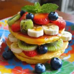 To prepare the Mini Pancake Fruit Stack, gather these key ingredients: - 1 cup all-purpose flour - 2 tablespoons granulated sugar - 1 tablespoon baking powder - 1/2 teaspoon fine salt - 1 cup milk (preferably whole or 2%) - 1 large egg, at room temperature - 2 tablespoons unsalted butter, melted and slightly cooled - 1/2 teaspoon pure vanilla extract - A variety of fresh fruits (e.g., strawberries, blueberries, banana slices, kiwi) for layering - Maple syrup or honey for drizzling - Fresh mint leaves for garnish (optional) These simple ingredients come together to form a delightful breakfast. The flour gives structure, while the sugar adds sweetness. Baking powder helps the pancakes rise, making them fluffy. The milk and egg create a rich batter. Melted butter adds flavor and moisture, and vanilla gives a warm aroma. Fresh fruits bring color, taste, and nutrition. Maple syrup or honey drizzled on top enhances the sweetness and ties everything together. Lastly, mint leaves add a refreshing touch. For the full recipe, follow the steps for a delightful layered breakfast. 1. Combine dry ingredients: In a large bowl, whisk together the flour, sugar, baking powder, and salt. This step helps to mix the dry items evenly. 2. Mix wet ingredients: In another bowl, whisk the milk, egg, melted butter, and vanilla extract. It should look smooth and creamy. Ensure the butter cools a bit, so it doesn't cook the egg. 3. Combine mixtures: Gradually pour the wet mix into the dry mix. Use a spatula to fold them together gently. It's okay if the batter is a little lumpy. Overmixing can make the pancakes tough. 1. Preheat skillet: Set a non-stick skillet or griddle on medium heat. Lightly grease it with butter or oil. This helps prevent sticking. 2. Cook mini pancakes: For each pancake, pour about 2 tablespoons of batter onto the hot skillet. Cook for 1-2 minutes. Look for small bubbles on the surface. Then, flip the pancake and cook for another 1-2 minutes until it turns golden brown. Repeat until you use all the batter. Adjust heat if needed. 1. Layering pancakes and fruits: On a plate, stack 3-4 mini pancakes. In between each pancake, add layers of fresh fruits. You can use strawberries, blueberries, banana slices, or kiwi. This adds flavor and makes it look pretty. 2. Finishing touches with syrup: Drizzle maple syrup or honey over your stack. Add more fresh fruit on top. For a nice touch, sprinkle some fresh mint leaves as a garnish. It makes the dish look fresh and bright. For the complete recipe, check the Full Recipe section. To make light and fluffy pancakes, avoid dense batter. Start with the right mixing. Gently fold the wet and dry ingredients. It’s okay to have lumps. Overmixing makes pancakes tough. Next, watch the cooking temperature. Preheat your skillet on medium heat. If it’s too hot, the outside burns before the inside cooks. If too cool, the pancakes won’t rise well. You want golden-brown pancakes, not charred ones. Make your pancake stack look great on the plate. Use colorful fruit like strawberries, blueberries, or kiwi. Place a layer of fruit between each pancake. This not only adds flavor but also makes it pretty. For a final touch, drizzle syrup over the stack. You can also add a light dusting of powdered sugar. This small detail makes your dish pop. One big mistake is overmixing the batter. Remember, lumps are okay! If you mix too much, your pancakes turn out tough. Another mistake is not preheating the skillet. If your skillet isn’t hot enough, the pancakes won’t cook right. Always give it a few minutes to heat before pouring in the batter. {{image_4}} You can make your mini pancake fruit stack even better with some tasty flavors. Try using flavored syrups like blueberry or strawberry. They add a fun twist. You can also use spreads, like Nutella or peanut butter, for added richness. Spices can also boost the taste. Adding a pinch of cinnamon or nutmeg gives your pancakes a warm, cozy flavor. Mix these spices into your dry ingredients for even distribution. Choosing the right fruits is key to a great pancake stack. Seasonal fruits work best. In spring and summer, use strawberries, blueberries, and peaches. In fall, opt for apples and pears. These fruits can add color and flavor. Think about pairing fruits, too. Bananas go great with strawberries, while kiwi adds a tart kick. Mix and match to find your favorite combos. You can easily tweak this recipe for different diets. For a gluten-free option, use a gluten-free flour blend instead of all-purpose flour. This keeps the pancakes light and tasty. If you want a vegan version, swap the egg for a flax egg or unsweetened applesauce. Use almond or oat milk to replace dairy milk. These changes still give fluffy pancakes without animal products. For the full recipe, check out the Mini Pancake Fruit Stack. To keep your mini pancakes fresh, store them in the fridge. Place them in an airtight container. This helps keep them soft and tasty. They can last up to three days in the fridge. When you're ready to eat them, reheating is simple. You can use a microwave or a skillet. For the microwave, heat for about 20-30 seconds. For the skillet, warm on low heat for 1-2 minutes. This keeps them fluffy and warm. Storing fresh fruit properly is key to keeping it tasty. Store fruits in the fridge in a breathable bag. This helps them stay fresh longer. Wash fruits just before eating to avoid moisture buildup. If you want convenience, frozen fruits work great too. They can be stored in the freezer for several months. Just thaw them before use, and they’re ready for your pancake stack. Mini pancakes can last in the fridge for about three days. If you want to store them longer, freeze them. In the freezer, they can last up to two months. Just wrap them tightly in plastic wrap and place them in a freezer bag. You can enjoy delicious pancakes anytime! For the full recipe, check out the [Full Recipe]. To make mini pancakes fluffy, focus on the batter. Use fresh ingredients like baking powder. Measure carefully. Mix the dry and wet ingredients separately. Then, combine them gently. Do not overmix! A few lumps are okay. Let the batter rest for five to ten minutes to let it rise. This step helps create air pockets for a light texture. Yes, you can make these pancakes ahead. Prepare the batter the night before. Store it in the fridge. When you're ready to cook, give the batter a quick stir. You can also cook the pancakes in advance. Stack them with parchment paper between layers. Store them in an airtight container. Reheat them in a toaster or skillet when you need them. Use a mix of sweet and tart fruits for flavor. Strawberries and blueberries are favorites. Sliced bananas add creaminess. Kiwi brings a bright color and flavor. Apples or peaches can also work well. Choose fruits that are in season for the best taste. Fresh fruits provide nutrients and make your stack look beautiful. Enjoy mixing and matching your favorites! You learned how to make delicious mini pancake stacks. We covered the key ingredients, step-by-step cooking methods, and tips for perfect pancakes. I shared ways to create fun flavors and dietary options. Finally, we discussed storing pancakes and fruit properly. Now, you can impress others with your tasty creations. Enjoy experimenting and have fun with your food!