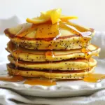 To make the best lemon poppy seed pancakes, gather these simple items: - 1 cup all-purpose flour - 1 tablespoon poppy seeds - 2 teaspoons baking powder - 1/4 teaspoon salt - 2 tablespoons granulated sugar - 1 cup milk - 1 large egg - 2 tablespoons melted butter (plus extra for cooking) - Zest of 1 lemon - 2 tablespoons fresh lemon juice - Maple syrup or honey for serving These ingredients blend to create a light and zesty pancake. The poppy seeds add a nice crunch, while the lemon zest and juice give a fresh flavor. You can use regular milk or choose a dairy-free option if you prefer. The sugar adds a hint of sweetness, balancing the tangy lemon. When cooking, the melted butter helps the pancakes brown nicely and adds a wonderful flavor. For the best results, use fresh lemon juice and zest. This will make your pancakes taste vibrant and bright. Enjoy making these pancakes with family or friends. They are perfect for a lazy weekend brunch or a quick weekday breakfast. Don't forget to top them with maple syrup or honey for an extra treat! {{ingredient_image_1}} First, grab a medium bowl. In this bowl, combine 1 cup of all-purpose flour, 1 tablespoon of poppy seeds, 2 teaspoons of baking powder, 1/4 teaspoon of salt, and 2 tablespoons of granulated sugar. Use a whisk to mix these ingredients well. Whisk until everything is fully combined. This step helps the dry ingredients blend together evenly. Next, take another bowl. In this bowl, beat together 1 cup of milk, 1 large egg, 2 tablespoons of melted butter, the zest of 1 lemon, and 2 tablespoons of fresh lemon juice. Make sure to mix until everything is well blended. This mixture gives your pancakes a rich and zesty flavor. Now, it’s time to combine the wet and dry ingredients. Gradually add the wet mixture to the dry ingredients. Stir gently until just combined. It's key to not overmix; a few lumps are okay. Overmixing can make your pancakes tough, and we want them light and fluffy. Before you start cooking, preheat a non-stick skillet over medium heat. Add a small dab of butter to the skillet. Once hot, pour about 1/4 cup of batter into the skillet for each pancake. Cook until bubbles form on the surface, which takes about 2-3 minutes. Check the edges; they should look set. Flip the pancakes carefully and cook for another 2-3 minutes until golden brown. Repeat this process until all the batter is used, adding more butter as needed for cooking. To make the best lemon poppy seed pancakes, lumps in the batter are vital. When you mix the wet and dry ingredients, stop as soon as you see some lumps. This helps keep the pancakes soft and fluffy. Overmixing can lead to tough pancakes. Remember, a few lumps are okay and even encouraged! Next, focus on cooking temperature and timing. Preheat your skillet over medium heat. If it's too hot, the pancakes may burn outside while staying raw inside. Once you pour the batter, cook until bubbles form on top. This usually takes about 2-3 minutes. Flip gently and cook for another 2-3 minutes until golden brown. For the best taste, serve your lemon poppy seed pancakes with sweet toppings. Maple syrup or honey are classic choices. They add a delightful sweetness that pairs well with the bright lemon flavor. You can also pair these pancakes with fresh fruits or yogurt. Sliced strawberries, blueberries, or even a dollop of Greek yogurt enhances the meal. The fruit adds freshness, while the yogurt brings creaminess. Together, they make your breakfast even more enjoyable! Pro Tips Use Fresh Ingredients: For the best flavor in your pancakes, use fresh lemon juice and zest. This will enhance the zesty profile of your dish. Don’t Overmix: When combining wet and dry ingredients, mix just until incorporated. Overmixing can lead to tough pancakes; a few lumps are perfectly fine. Check Heat Level: Ensure your skillet is at the right temperature by doing a test pancake. If it browns too quickly, reduce the heat; if it takes too long, increase the heat. Experiment with Toppings: While maple syrup or honey is delicious, try adding fresh berries, yogurt, or a sprinkle of powdered sugar for a fun twist! {{image_2}} You can make these pancakes gluten-free. Substitute the all-purpose flour with a gluten-free blend. Look for a mix that contains xanthan gum. This helps the pancakes hold together. Follow the same steps in the recipe. You may notice a slightly different texture. But they will still taste great! To make these pancakes vegan, replace the egg with a flaxseed egg. Mix 1 tablespoon of ground flaxseed with 2.5 tablespoons of water. Let it sit for a few minutes to thicken. For the milk, use almond milk or oat milk. Instead of butter, use coconut oil or vegan butter. These swaps keep the pancake moist and tasty. You can add extra flavors to your pancakes. Try folding in fresh blueberries before cooking. They add sweetness and a pop of color. You can also mix in some lemon zest for a stronger lemon flavor. Other citrus zests like orange or lime can work well too. This way, each bite bursts with flavor. Enjoy experimenting with these tasty options! After you make your lemon poppy seed pancakes, you may have extras. To store them, follow these tips: - Refrigeration Tips: Place pancakes in an airtight container. They will stay fresh for up to three days in the fridge. I like to put a piece of wax paper between layers. This keeps them from sticking together. - Freezing Instructions: For longer storage, freeze pancakes. Place them in a single layer on a baking sheet. Once frozen, stack them in a freezer bag. They can last for up to two months. Just remember to label the bag with the date. When it's time to eat your pancakes again, reheating them is key to keeping them tasty. Here are the best methods: - Best Methods to Retain Texture: The best way to reheat pancakes is in the oven. Preheat it to 350°F (175°C). Place pancakes on a baking sheet and cover them with foil. Heat for about 10 minutes. This keeps them warm and soft. - You can also use a microwave. Place a pancake on a plate and cover it with a damp paper towel. Heat for 20-30 seconds. This method is quick but may make them a bit chewy. By following these storage and reheating tips, your lemon poppy seed pancakes will still taste great! Using lemon extract can change the taste. Extract is more concentrated than zest and juice. You may get a strong lemon flavor, but it won't have the same fresh taste. Zest adds oils and aroma, making pancakes bright and lively. Juice brings acidity and moisture. For the best flavor, use both zest and juice. To make your pancakes fluffier, use fresh baking powder. Check the date on the package. Also, do not overmix the batter. Lumps are okay; they help keep air in the mix. Let the batter sit for a few minutes before cooking. This allows the baking powder to start working, making your pancakes rise nicely. Poppy seeds are tiny seeds from the poppy flower. They add a nutty flavor and a slight crunch. These seeds boost nutrition too. They are rich in fiber, calcium, and healthy fats. Poppy seeds can help with digestion and heart health. Their unique taste pairs well with lemon, making your pancakes special. You learned about making tasty lemon poppy seed pancakes from scratch. We covered the key ingredients, mixing methods, and cooking tips. You can even explore variations like gluten-free or vegan options. Don’t forget to try different toppings to enhance your pancakes. With these steps, you can whip up the perfect breakfast treat. Enjoy these delightful pancakes any day. Your family and friends will love them! Happy cooking!