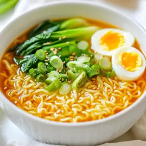 - 2 packs of instant ramen noodles (discard the seasoning packets) - 4 tablespoons unsalted butter - 6 cloves garlic, minced - 1 tablespoon red pepper flakes (adjust to taste) - 4 cups chicken or vegetable broth - 2 tablespoons soy sauce - 2 green onions, thinly sliced - 1 cup baby spinach or bok choy - Sesame seeds for garnish - Soft-boiled eggs (optional) I love using instant ramen noodles for this recipe. They cook quickly and soak up flavors well. Discard the seasoning packets since we will create our own rich taste. Unsalted butter gives the broth a creamy texture. The fresh garlic adds a strong, savory base. Red pepper flakes bring heat, but you can adjust this to your taste. The broth is crucial. Chicken or vegetable broth provides depth. Soy sauce adds a salty umami kick. Green onions and spinach or bok choy add freshness and color, making the dish pop. Finishing with sesame seeds adds a nice crunch. If you want, add soft-boiled eggs on top for extra protein and richness. You can swap in other vegetables like mushrooms or bell peppers if you prefer. If you need gluten-free noodles, look for rice noodles or gluten-free ramen. For a lighter dish, consider low-sodium broth options. To kick up the flavor, you can add a splash of lime juice or a dash of sesame oil. Fresh herbs like cilantro or basil add brightness too. Consider adding more spices like ginger or a spoonful of miso for extra depth. {{ingredient_image_1}} To start, fill a pot with water and bring it to a boil. Once boiling, add the instant ramen noodles. Cook them for about 3 to 4 minutes. You want them tender but not mushy. Keep an eye on the timer to avoid overcooking. After cooking, drain the noodles and set them aside. For best results, use a large pot. This allows the noodles to move freely. Stir them gently while cooking to prevent sticking. Next, grab a large skillet and place it over medium heat. Add 4 tablespoons of unsalted butter. Let it melt slowly. Once melted, add 6 cloves of minced garlic and 1 tablespoon of red pepper flakes. Sauté this mixture for 1 to 2 minutes. The goal is to make the garlic fragrant, not burnt. Stir it constantly to avoid any burning. This garlic butter sauce is the heart of the dish. It gives the ramen rich flavor and a lovely aroma. Now, pour in 4 cups of chicken or vegetable broth along with 2 tablespoons of soy sauce. Bring this mixture to a gentle simmer. Let it simmer for about 5 minutes to blend the flavors well. After the broth simmers, it’s time to add the cooked noodles. Gently stir to coat the noodles with the garlic butter broth. This step is crucial for flavor. Next, toss in 1 cup of baby spinach or bok choy. Cook for about 1 to 2 minutes until wilted. This adds color and nutrition to your ramen. For a great presentation, ladle the spicy garlic butter ramen into bowls. Top each bowl with sliced green onions and sesame seeds. If you like, add soft-boiled eggs for a nice touch. To serve, use a wide soup spoon or a deep bowl. This makes it easy to enjoy every bite. For an extra pop of flavor, drizzle some melted garlic butter on top before serving. To adjust spice levels, start small. Add red pepper flakes slowly. Taste as you go. You can make it mild or fiery. For a richer broth, add more soy sauce or a splash of mirin. This will deepen the taste. A dash of sesame oil can also boost flavor. When boiling noodles, use a big pot. This helps them cook evenly. Stir them gently to avoid sticking. For sautéing garlic, keep the heat medium. This helps prevent burning. If you're short on time, use leftover broth. It speeds up the cooking process. Get creative with garnishes. Try a sprinkle of sesame seeds or a drizzle of extra garlic butter. Use bright green onions for color. To plate like a pro, use a deep bowl. Layer the noodles first, then pour broth over. Add greens last for a fresh look. Pro Tips Adjust Spice Level: If you prefer a milder dish, reduce the amount of red pepper flakes or omit them entirely. You can always add more spice later if desired. Butter Quality Matters: Use high-quality unsalted butter for a richer flavor. If you want to experiment, try adding a flavored butter, like garlic herb butter, for an extra kick. Fresh Herbs Enhance Flavor: Consider adding fresh herbs like cilantro or basil just before serving. They add a delightful freshness that complements the rich garlic butter. Customize Your Toppings: Get creative with toppings—try adding sliced mushrooms, shredded carrots, or even a sprinkle of chili oil for additional flavor and texture. {{image_2}} You can boost your ramen with added protein. Chicken, shrimp, and tofu work well. - For chicken, use cooked, shredded pieces. - Shrimp cooks quickly and adds a nice taste. - Tofu is great for a vegetarian option. Just cube it and add to the broth. For vegan choices, use firm tofu or tempeh. Both absorb flavors well and keep the meal filling. Spicy garlic butter ramen can adapt to your taste. - If you want it milder, reduce the red pepper flakes. - Try adding ginger for a fresh kick or lime for brightness. You can also explore regional twists. For a Korean flair, add gochujang. For a Japanese touch, use miso paste. You can change the broth to fit your taste. - Use vegetable broth for a lighter option. - For more richness, try adding coconut milk. You can also switch up the seasonings. Add a splash of fish sauce for depth. If you want a creamy broth, blend in some sesame paste or miso. Both give a nice texture and flavor. After you make spicy garlic butter ramen, keep it in the fridge. Place the ramen in an airtight container. It stays fresh for about 3 days. Before eating, check for any odd smells or changes in color. If it seems off, toss it out. You can freeze ramen leftovers for later. First, let it cool completely. Then, put it in a freezer-safe container. It can last up to 2 months in the freezer. When you're ready to eat, thaw it in the fridge overnight. For reheating, use a pot on the stove or the microwave. Add a splash of broth or water to keep it moist. Meal prep makes cooking easy. You can make a big batch of spicy garlic butter ramen. Divide it into individual portions. Use small containers for quick meals. When hunger strikes, just grab a container and heat it. This way, you save time and enjoy tasty ramen anytime. Yes, you can! To make it vegan, use plant-based butter. For the broth, pick vegetable broth. This keeps the dish rich and tasty without animal products. To tone down the heat, reduce the red pepper flakes. You can also add more butter to balance the spice. A touch of sugar can help too. The total time is about 20 minutes. Prep takes about 10 minutes. Cooking the noodles and sauce takes another 10 minutes. It’s quick and easy! Fresh noodles work great! Just cook them per the package instructions. They may take a bit longer than instant noodles but will add a nice texture. In this post, I shared how to make a tasty garlic butter ramen dish. You learned about the main ingredients, flavor enhancements, and easy steps to cook. I also covered tips, variations, and how to store leftovers. Ramen is fun to customize, so feel free to mix and match ingredients. With a little creativity, you can make this dish your own. Enjoy your cooking adventure!