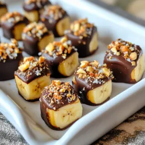 To make chocolate-covered banana bites, you need some simple ingredients. Gather these items for a tasty treat: - Ripe bananas - 1 cup dark chocolate chips (or milk chocolate if preferred) - 1 tablespoon coconut oil - 1/4 cup chopped nuts (walnuts or almonds) - 1/4 cup shredded coconut (optional) - Sea salt for sprinkling (optional) These ingredients bring the best flavors together. Ripe bananas offer natural sweetness. Dark chocolate chips melt easily and give a rich taste. Coconut oil helps the chocolate become smooth and shiny. Chopped nuts add crunch and flavor, while shredded coconut can bring a tropical twist. A sprinkle of sea salt enhances the sweetness of the chocolate. You can mix and match some ingredients to suit your taste. Enjoy the fun of creating this easy and tasty treat! {{ingredient_image_1}} - First, peel the bananas. - Next, slice them into 1-inch thick rounds. Set them aside. - In a microwave-safe bowl, mix dark chocolate chips and coconut oil. - Microwave this mix in 30-second bursts, stirring in between. Keep going until it is smooth. - Line a baking sheet with parchment paper for easy cleanup. - Dip each banana slice into the melted chocolate. Ensure it's fully coated. - Use a fork to lift the slice and let excess chocolate drip off. - Place each coated slice on the lined baking sheet. - For a crunch, add chopped nuts on top of the coated banana. - You can also sprinkle shredded coconut for extra flavor. - A pinch of sea salt adds a nice touch if you like it sweet and salty. - After coating all the banana slices, put the baking sheet in the freezer. - Freeze for about 30 minutes, or until the chocolate is firm. - Serve them chilled or at room temperature for a tasty treat. Enjoy your chocolate-covered banana bites! To melt chocolate, use a microwave-safe bowl. Add chocolate chips and coconut oil. Heat in 30-second bursts. Stir after each round. Keep heating until smooth. This method keeps the chocolate from burning. For an even coating, dip each banana slice fully. Use a fork to lift it out. Let excess chocolate drip off. This way, you avoid clumps. Arrange your banana bites on a nice plate. Place them in a single layer for a clean look. You can also stack them for fun. Use colorful paper liners to add charm. For serving, consider adding fruit skewers. They make a great party treat. You can also serve them with a drizzle of melted chocolate. If you need more bites, just double the recipe. Use four bananas and two cups of chocolate chips. For fewer bites, use one banana. Adjust the other ingredients too. This way, you always have the right amount. Pro Tips Choose Ripe Bananas: The riper the bananas, the sweeter and more flavorful your bliss bites will be. Look for bananas with brown spots for optimal sweetness. Use Quality Chocolate: Opt for high-quality dark or milk chocolate for better flavor and a smoother texture. It makes a significant difference in the final taste! Experiment with Toppings: Feel free to customize your toppings! Try adding mini chocolate chips, dried fruits, or seeds for added texture and flavor. Store Properly: Keep your bliss bites in an airtight container in the freezer for up to a month. Let them sit at room temperature for a few minutes before serving for the best texture. {{image_2}} You can switch up the chocolate for a fun twist. Try white chocolate if you want a sweeter taste. It gives a nice color too. For a lighter option, use yogurt. Greek yogurt works well and adds a creamy texture. Both options make your banana bites unique and tasty. Want to spice things up? Add cinnamon or nutmeg to the melted chocolate. These spices give a warm flavor that pairs nicely with bananas. You can also infuse flavors like vanilla extract. Just a drop can make your bites more aromatic and special. Dips and drizzles add extra fun. You can make a chocolate drizzle with extra melted chocolate. Just take a spoon and drizzle it over your bites after coating. Peanut butter or almond butter is another great choice. A light drizzle of nut butter adds creaminess and richness. To keep your chocolate-covered banana bites fresh, you have two great options: - Storing in the refrigerator: Place the bites in a covered container. This keeps them cool and tasty. They will stay fresh for a few days in the fridge. - Freezing banana bites: For longer storage, the freezer is best. Arrange the bites in a single layer on a baking sheet. Once frozen, transfer them to a freezer-safe bag. This helps them avoid freezer burn. How long do they last in the fridge? Chocolate-covered banana bites can last about 3 to 5 days in the refrigerator. Their taste and texture will stay good for this time. How long do they last in the freezer? If you freeze them, they can last up to 2 months. They will still taste yummy when you pull them out later. How do you thaw frozen bites safely? There are two simple methods: 1. In the refrigerator: Transfer the bites from the freezer to the fridge. Let them sit overnight to thaw slowly. 2. At room temperature: If you're in a hurry, place them on the counter for about 15 to 30 minutes. This will help them thaw quickly while keeping them tasty. To make chocolate-covered banana bites, follow these easy steps: 1. Peel and slice two ripe bananas into 1-inch thick rounds. 2. In a microwave-safe bowl, mix 1 cup of dark chocolate chips and 1 tablespoon of coconut oil. 3. Microwave this mix in 30-second intervals, stirring until it's smooth. 4. Line a baking sheet with parchment paper. 5. Dip each banana slice in the melted chocolate. 6. Use a fork to lift the slice and let excess chocolate drip off. 7. Place the coated slice on the parchment paper. 8. Sprinkle with chopped nuts or shredded coconut if you like. 9. Freeze for about 30 minutes until the chocolate sets. These bites are fun and quick to make! Yes, you can use other types of chocolate! - Milk chocolate gives a sweeter taste. - White chocolate adds a creamy touch. - You can even try dark chocolate for a richer flavor. Just remember to adjust the sweetness of your toppings to match. Chocolate-covered banana bites have some healthy aspects. - Bananas are full of potassium and fiber. - Dark chocolate contains antioxidants. - Nuts add healthy fats and protein. Using dark chocolate can make them a bit healthier. Enjoy them in moderation for a tasty treat! You now know how to make tasty chocolate-covered banana bites. We covered the ingredients, preparation steps, and topping options. I shared tips for perfect coatings and fun variations to try. These bites store well, whether in the fridge or freezer. You can enjoy them for a snack or treat at any time. Whichever way you choose to indulge, these bites will please everyone. Get ready to impress your friends and family with this simple recipe. Enjoy making and sharing your delicious chocolate-covered banana bites!