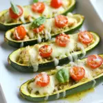 To make pesto chicken zucchini boats, you need these ingredients: - 4 medium zucchinis - 2 cups cooked chicken, shredded - 1 cup basil pesto, store-bought or homemade - 1 cup cherry tomatoes, halved - 1 cup mozzarella cheese, shredded - 1/2 cup grated Parmesan cheese - Olive oil for drizzling - Salt and pepper, to taste - Fresh basil leaves for garnish (optional) These ingredients come together to create a tasty dish. The zucchini acts as a perfect base, while the chicken and pesto mix adds great flavor. You can easily swap some ingredients if needed. Here are some ideas: - If you don't have zucchinis, use bell peppers or eggplants. - For the chicken, you can use turkey or cooked shrimp. - Store-bought pesto works, but homemade tastes even better. You can blend fresh basil, garlic, nuts, and olive oil to make it. - If you want a lighter cheese, try using part-skim mozzarella. - For a dairy-free option, skip the cheese or use a dairy-free substitute. These swaps let you customize the dish to fit your tastes or what you have on hand. Each serving of pesto chicken zucchini boats is packed with nutrients. Here’s what you can expect: - Calories: About 400 - Protein: 30g - Carbohydrates: 10g - Fat: 25g - Fiber: 3g This meal is rich in protein and healthy fats. It provides a good balance that makes it great for lunch or dinner. Enjoy your cooking! {{ingredient_image_1}} To start, gather your zucchinis. You need four medium zucchinis for this recipe. Slice each one in half lengthwise. Use a spoon to scoop out the seeds and some flesh. This creates a boat shape. Place the cut zucchinis, cut-side up, on a baking sheet. Drizzle a little olive oil over them. Then, sprinkle each boat with salt and pepper. This adds flavor and helps with cooking. Now, let’s make the filling. In a large bowl, mix two cups of shredded chicken with one cup of basil pesto. You can use store-bought or homemade pesto. Next, add one cup of halved cherry tomatoes to the bowl. Mix everything well. Now, take half a cup of shredded mozzarella cheese and add it to the mixture. Stir until all ingredients blend nicely. It’s time to fill the boats! Spoon the chicken-pesto mixture into each zucchini half. Make sure to divide it evenly. After that, top each boat with the remaining mozzarella cheese. Then, sprinkle half a cup of grated Parmesan cheese on top. Now, preheat your oven to 375°F (190°C). Bake the zucchini boats for 25-30 minutes. Look for tender zucchini and bubbly, golden cheese. Once done, take them out of the oven. Let them cool for a few minutes. If you like, garnish with fresh basil leaves before serving. Enjoy your flavorful dish! To get perfectly cooked zucchini, choose medium-sized zucchinis. They hold their shape well. Slice them in half lengthwise, then scoop out the seeds. This helps them cook evenly. Drizzle olive oil on top and season with salt and pepper. Bake at 375°F for 25-30 minutes. You want the zucchini to be tender, not mushy. Keep an eye on them as they cook. You can boost the flavor of your zucchini boats easily. Try adding sautéed onions or garlic to the chicken mixture. They add a nice touch. Chopped spinach or bell peppers work well too. For some heat, add crushed red pepper flakes. A squeeze of lemon juice brightens the dish. Don't forget to use fresh herbs like parsley or basil for added freshness. Avoid overcooking the zucchini. It should be tender but still firm. Don't skip the seasoning; it enhances the flavors. Also, use enough pesto. It adds moisture and flavor. If you stuff the boats too much, they may spill over. Make sure to fill them evenly. Lastly, let the boats cool slightly before serving. This helps the flavors settle and makes them easier to eat. Pro Tips Choosing Zucchini: Select medium-sized zucchinis that are firm and have a glossy skin for the best flavor and texture. Homemade Pesto: If you have time, consider making your own basil pesto using fresh basil, garlic, pine nuts, and olive oil for a fresher taste. Cheese Variations: Feel free to experiment with different cheeses such as feta or goat cheese for a unique flavor profile. Meal Prep Friendly: These zucchini boats can be prepped ahead of time and stored in the refrigerator for a quick and healthy weeknight meal. {{image_2}} If you want a vegetarian twist, swap the chicken with chickpeas or lentils. Both options offer protein and fiber. You can also add diced bell peppers or spinach for more veggies. Mix these with basil pesto and stuff the zucchini boats. This version is just as tasty and filling. You can use different proteins for the filling. Shredded turkey or cooked shrimp work great. For a lighter choice, try using tofu or tempeh. Just make sure to season them well, so they absorb the flavors. Each protein brings a unique taste to the dish, making it fun to experiment. Pesto sauce is versatile. You can change its flavor by adding nuts like walnuts or almonds. For a spicy kick, mix in red pepper flakes. If you want a creamier sauce, blend in some Greek yogurt or cream cheese. Fresh herbs like parsley or cilantro can also add a new layer of flavor. Each variation can turn your zucchini boats into a whole new dish! To store leftovers, let the zucchini boats cool down first. Place them in an airtight container. You can keep them in the fridge for up to three days. If you want to keep them longer, consider freezing them. Make sure to wrap them well in plastic wrap or aluminum foil. When you’re ready to eat, preheat your oven to 350°F (175°C). Place the zucchini boats on a baking tray. Cover them with foil to keep them moist. Heat for about 15 to 20 minutes. Check if they are hot throughout. You can also use a microwave. Heat in short bursts, about one minute at a time. Freezing is a great way to save these boats for later. After cooling, wrap each boat tightly in plastic wrap. Place the wrapped boats in a freezer bag. Label the bag with the date. They will stay fresh for up to three months. To eat, thaw them overnight in the fridge before reheating. Yes, you can prepare these zucchini boats ahead of time. Assemble them up to a day before serving. Just store them in the fridge, covered. When ready to eat, bake them straight from the fridge. You may need to add a few extra minutes to the cooking time. You know the zucchini is done when it is tender. A fork should slide in easily. The cheese on top should be bubbly and slightly browned. If you see this, it's perfect to take out of the oven. A fresh salad pairs well with pesto chicken zucchini boats. Try a simple mixed greens salad with lemon vinaigrette. Grilled asparagus or roasted vegetables make a great side too. For something heartier, serve with brown rice or quinoa. In this blog post, we covered how to make delicious pesto chicken zucchini boats. We discussed the ingredients you'll need and offered substitutions. You learned the step-by-step instructions for prepping and baking. I shared tips for perfect cooking and flavor boosts. We explored variations, storage methods, and answered common questions. Cooking can be fun and easy. Follow these steps to impress your family and friends. Enjoy your tasty, healthy meal!