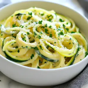 - 4 medium zucchinis (spiralized into noodles) - 3 tablespoons olive oil - 4 cloves garlic, minced - 1 cup heavy cream - 1 cup freshly grated Parmesan cheese - 1 teaspoon garlic powder - 1/2 teaspoon salt - 1/4 teaspoon black pepper - 1/4 teaspoon nutmeg (optional) - Fresh parsley, chopped (for garnish) To make Garlic Parmesan Zoodle Alfredo, you need fresh ingredients. Start with four zucchinis. Spiralize them into noodles, which we call zoodles. You can use a spiralizer or a veggie peeler. Set these zoodles aside for later. Next, you need three tablespoons of olive oil. This oil gives flavor and helps cook the garlic. Garlic is key in this dish. You will need four cloves, minced finely. Fresh garlic makes the sauce fragrant and tasty. For creaminess, use one cup of heavy cream. This is what makes the Alfredo sauce rich. You also need one cup of freshly grated Parmesan cheese. This cheese adds a salty and nutty flavor. Grating it fresh gives the best texture. Don't forget the spices! Add one teaspoon of garlic powder, half a teaspoon of salt, and a quarter teaspoon of black pepper. If you like, add a quarter teaspoon of nutmeg. Nutmeg gives a warm, subtle flavor. Lastly, chop some fresh parsley for garnish. It adds color and freshness to your dish. Gather these ingredients, and you're ready to create a creamy and simple Garlic Parmesan Zoodle Alfredo! {{ingredient_image_1}} To start, grab 4 medium zucchinis. Use a spiralizer to turn them into zoodles. This tool makes thin, noodle-like strips from the zucchini. Once you spiralize all the zucchinis, set the zoodles aside. Keep them out of the way while you cook. Next, heat 3 tablespoons of olive oil in a large skillet over medium heat. Add 4 cloves of minced garlic to the hot oil. Cook the garlic for about 1 to 2 minutes. You want it to smell great but not turn brown. This step adds a rich flavor to your dish. Now, reduce the heat to low. Pour in 1 cup of heavy cream. Stir it well to mix with the garlic. Gradually add 1 cup of freshly grated Parmesan cheese. Also, add 1 teaspoon of garlic powder, 1/2 teaspoon of salt, and 1/4 teaspoon of black pepper. If you like, sprinkle in 1/4 teaspoon of nutmeg. Keep stirring until the cheese melts into a smooth sauce. Next, raise the heat back to medium. Add the zoodles to the skillet with the Alfredo sauce. Toss the zoodles gently so they coat well. Cook them for about 3 to 5 minutes. You want them tender yet still a bit crunchy. Once done, remove the skillet from heat. Transfer the Garlic Parmesan Zoodle Alfredo to a serving dish. For a nice touch, garnish with freshly chopped parsley. You can also add a bit more grated Parmesan on top. Enjoy your creamy, simple dish! To make zoodles great, avoid overcooking them. Cook for just 3-5 minutes. This keeps them crunchy. If they cook too long, they become mushy and sad. Always test a piece before removing them from heat. To keep zoodles crunchy, use fresh zucchinis. Spiralize them just before cooking. This helps them stay firm and flavorful. Adding spices can take your dish to the next level. Try red pepper flakes for heat, or fresh basil for freshness. These little changes can make a big impact. Choosing the right Parmesan is key. Use freshly grated cheese. It melts better and tastes richer than pre-grated options. This will make your sauce smooth and creamy. For the best results, use a large skillet. A wider surface helps the zoodles cook evenly. It allows steam to escape, keeping them crisp. Managing heat levels is also important. Start with medium heat to sauté garlic. Lower the heat when adding cream. This prevents the sauce from burning and keeps it silky smooth. Pro Tips Choose Firm Zucchini: Select firm zucchinis for best results; they will hold their shape better and provide a satisfying texture for your zoodles. Don’t Overcook Zoodles: Zoodles should be cooked just until tender to prevent them from becoming mushy; aim for a slight crunch for optimal texture. Fresh Parmesan is Key: Use freshly grated Parmesan cheese rather than pre-grated for a creamier texture and richer flavor in your Alfredo sauce. Add Protein: For a heartier meal, consider adding grilled chicken, shrimp, or sautéed mushrooms to your zoodle dish for extra flavor and nutrition. {{image_2}} You can boost your Garlic Parmesan Zoodle Alfredo by adding protein. Grilled chicken works great. It gives a nice, savory flavor. Slice it thin and mix it in with the zoodles. Shrimp is another tasty option. Sauté the shrimp in olive oil until they turn pink. Then, toss them in with the zoodles for a seafood twist. If you want a plant-based option, try tofu. Cube it and sauté it with the garlic before adding the cream. Each choice brings a new taste to the dish. While Parmesan is classic, you can try Pecorino Romano for a sharper taste. It adds a nice kick that pairs well with the cream. Just grate it like you would Parmesan and stir it in. If you're looking for dairy-free options, there are great alternatives. Nutritional yeast gives a cheesy flavor without dairy. You can also find plant-based cheeses that melt well. Just make sure they fit your taste. Zoodles are fun, but you can add more vegetables too. Spinach or kale adds color and nutrients. Stir them in with the zoodles in the last few minutes of cooking. You can also spiralize other vegetables. Carrots work well and add a sweet crunch. Mix these in for a vibrant and healthy dish. Each vegetable adds its own flair, making the meal even more exciting. To keep your Garlic Parmesan Zoodle Alfredo fresh, use airtight containers. Glass or BPA-free plastic containers work well. Store the dish in the fridge within two hours of cooking. Leftovers can last for about 3 days. You can use the microwave or the stovetop to reheat. For the microwave, place the zoodles in a bowl and cover it. Heat in short bursts of 30 seconds, stirring in between. On the stovetop, use a skillet over low heat. Add a splash of cream to keep it moist. This method helps prevent sogginess. You can freeze this dish, but the texture may change. To freeze, let it cool completely. Place it in a freezer-safe container, leaving space for expansion. It can last for up to 3 months in the freezer. To enjoy later, thaw it overnight in the fridge. Reheat it on the stovetop, adding a little cream to restore its creaminess. Zoodles are zucchini noodles. They are a fun and healthy twist on pasta. Zoodles are low in carbs and calories. They offer vitamins A and C. They also have fiber, which is good for digestion. Plus, they add a fresh taste to any dish. Yes, you can. To make this dish vegan, swap the heavy cream for coconut milk. Use a vegan cheese instead of Parmesan. Nutritional yeast can also add a cheesy flavor. These changes keep the dish creamy and tasty. This recipe is already gluten-free with zoodles. Always check ingredient labels for hidden gluten. Ensure the cheese and spices are gluten-free. This way, you can enjoy it without worry. Zoodles can last about 2 to 3 days in the fridge. Store them in a sealed container. Keep them dry to avoid sogginess. It’s best to eat them fresh for the best taste. Yes, you can use store-bought zoodles. They save time and effort. Just check the package for freshness. Pre-packaged zoodles may have added preservatives. They can also be a bit softer in texture. Use them if you need a quick option. This blog post shared how to make zoodles with a rich Alfredo sauce, covering key ingredients, step-by-step instructions, and helpful tips. You learned how to keep your zoodles crunchy and enhance flavors with spices. I also suggested protein additions and alternative cheeses. Feel free to store leftovers and reheat them without losing quality. Lastly, remember that you can customize this dish to fit your needs—vegan or gluten-free options are available. Enjoy your zoodle journey with confidence and deliciousness!
