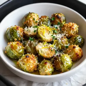 - 1 lb Brussels sprouts, trimmed and halved - 3 tablespoons olive oil - 4 cloves garlic, minced - 1/4 cup grated Parmesan cheese - 1 teaspoon Italian seasoning - Salt and pepper to taste - Optional: Zest of 1 lemon For this recipe, I use 1 pound of Brussels sprouts. This is enough for about four servings. You will need three tablespoons of olive oil to help the sprouts crisp up nicely. Four cloves of garlic give lots of flavor. The Parmesan cheese adds a rich taste, so I use a quarter cup of grated cheese. One teaspoon of Italian seasoning adds a nice touch. Don't forget to season with salt and pepper to your liking. If you want a fresh twist, add the zest of one lemon. If you&rsquo;re feeling adventurous, the lemon zest is a great option. It brings a bright flavor to the dish. You can also try adding chili flakes for some heat or even a dash of balsamic vinegar for extra depth. These optional ingredients can change the dish to fit your taste. {{ingredient_image_1}} 1. First, gather your ingredients. You need: - 1 lb Brussels sprouts, trimmed and halved - 3 tablespoons olive oil - 4 cloves garlic, minced - 1/4 cup grated Parmesan cheese - 1 teaspoon Italian seasoning - Salt and pepper to taste - Optional: Zest of 1 lemon 2. Preheat your air fryer to 375&deg;F (190&deg;C). This step is key for crispiness. 3. In a large bowl, combine the halved Brussels sprouts and olive oil. 4. Add the minced garlic, Italian seasoning, salt, and pepper. Toss well until the sprouts are evenly coated. 5. Now, sprinkle the grated Parmesan cheese into the bowl. Toss again to mix it well with the sprouts. 1. Place the Brussels sprouts in the air fryer basket in a single layer. Avoid crowding for even cooking. 2. Cook them for about 12 to 15 minutes. Shake the basket halfway through. This helps them brown evenly. 3. Check for doneness. They should be crispy and golden brown. 4. If you like, sprinkle the lemon zest over the hot Brussels sprouts. This adds a bright flavor. 1. Serve the air-fried Brussels sprouts in a rustic bowl. 2. Add a sprinkle of extra grated Parmesan on top for a nice touch. 3. Garnish with fresh parsley for color and freshness. Enjoy these tasty bites! They make a great side dish for any meal. To make your Brussels sprouts crisp, pick fresh ones. Look for bright green, firm sprouts. Trim the ends and cut them in half to help them cook evenly. Toss them well with olive oil and seasoning. This helps the flavors stick. Preheat your air fryer to 375&deg;F (190&deg;C). This step ensures they cook perfectly. Cook in batches if needed. Overcrowding will make them steam instead of crisp. Add minced garlic for a strong flavor. It gives a nice kick to each bite. Parmesan cheese adds a savory touch. For a zing, try lemon zest. This brightens the dish and adds freshness. You can also mix in spices like paprika or red pepper flakes for heat. Serve Brussels sprouts hot for the best taste. They pair well with roasted meats or fish. Try them alongside grilled chicken or steak. You can also enjoy them as a snack with a dip. Consider a creamy ranch or a tangy yogurt sauce for extra flavor. Pro Tips Choose Fresh Brussels Sprouts: Look for firm, bright green Brussels sprouts with tightly packed leaves for the best flavor and texture. Don't Skip the Preheating: Preheating your air fryer ensures that the Brussels sprouts cook evenly and get that desired crispy texture. Adjust Cooking Time for Different Sizes: If your Brussels sprouts are larger or smaller than average, adjust the cooking time accordingly to avoid undercooking or burning. Experiment with Seasonings: Feel free to add other spices like smoked paprika or chili flakes to customize the flavor profile to your liking. {{image_2}} You can change up the flavors in this dish easily. Instead of Italian seasoning, try using smoked paprika for a nice kick. Or mix in some chili flakes for heat. If you want a zesty twist, add lemon pepper seasoning. This gives a fresh taste that brightens the dish. If you don&rsquo;t have an air fryer, you can roast these sprouts in the oven. Preheat your oven to 400&deg;F (200&deg;C). Spread the sprouts on a baking sheet and cook for about 20-25 minutes. Keep an eye on them. You want them crispy and golden brown. You can also steam them first, then finish in a hot skillet for crispiness. Don&rsquo;t have Brussels sprouts? Use cauliflower florets instead. They cook well and soak up flavors nicely. If you want a nutty taste, swap Parmesan with nutritional yeast. This keeps it vegan while adding flavor. You can also replace olive oil with avocado oil for a different taste. Store any leftover Brussels sprouts in an airtight container. Keep them in the fridge. They stay fresh for about 3 days. Make sure they cool down before you store them. This helps keep them crispy longer. To reheat, use the air fryer for the best result. Set it to 350&deg;F (175&deg;C). Heat the Brussels sprouts for about 5 minutes. This brings back their crispiness. You can also use a microwave, but they may get soft. If you use the microwave, heat in 30-second bursts. You can freeze cooked Brussels sprouts, but they may lose some crunch. Let them cool before freezing. Place them in a freezer-safe bag. They can last up to 3 months. When ready to eat, thaw in the fridge overnight. Reheat in the air fryer for best results. You should cook Brussels sprouts in the air fryer for about 12 to 15 minutes. Start at 375&deg;F (190&deg;C). Halfway through, shake the basket. This helps them cook evenly. You want them to be crispy and golden brown. If they need more time, cook for an extra few minutes. Yes, you can make this recipe without Parmesan cheese. If you skip the cheese, try adding more garlic or herbs. Nutritional yeast can also give a cheesy flavor. This way, you still get a tasty dish without dairy. Customize it to suit your diet! These Brussels sprouts pair well with many dishes. Try serving them with grilled chicken or fish. They also go great with pasta or risotto. For a vegetarian meal, serve them with quinoa or a grain salad. Add a fresh salad for a nice crunch! In this post, we covered essential ingredients, preparation, and cooking steps for Brussels sprouts. I shared tips for cooking and flavoring to enhance your dish. We also explored variations and storage methods to keep leftovers fresh. Now, you can enjoy tasty Brussels sprouts any time! With these steps, tips, and tricks, cooking will be simple and fun. Try different flavors and cooking methods to find what you love best. Enjoy your tasty creations!